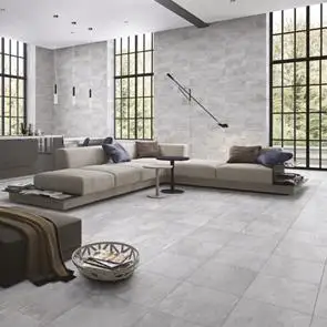 Open plan living room fully tiled with nature grey tiles, with the 500x500 floor tile and matching 690x240 on the wall with large floor to ceiling black framed windows